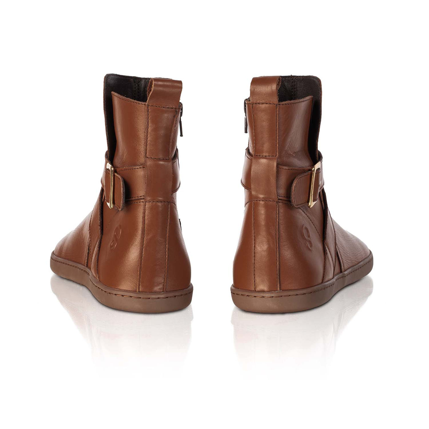 A photo of the Shapen Divine ankle boots made with a smooth leather upper, a microline lining, and rubber soles. The boots are brown in color and have an ankle strap with a gold buckle, as well as a side zipper. Both boots are shown from behind on a white background. #color_brown