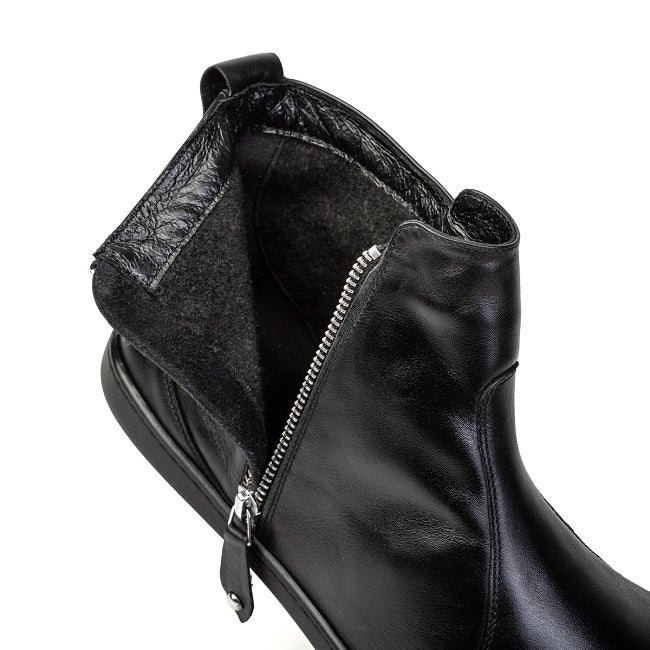 A photo of Shapen Ivy Chelsea boots made from smooth leather and rubber soles. The boots are black in color with stitching detailing and have a silver zipper with a leather tab on the side. One boot is shown unzipped to to show the fleece inside against a white background. #color_black