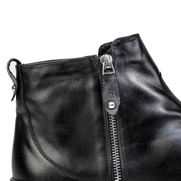 A photo of Shapen Ivy Chelsea boots made from smooth leather and rubber soles. The boots are black in color with stitching detailing and have a silver zipper with a leather tab on the side. One boot is shown up close from the right side by the back zipper against a white background. #color_black