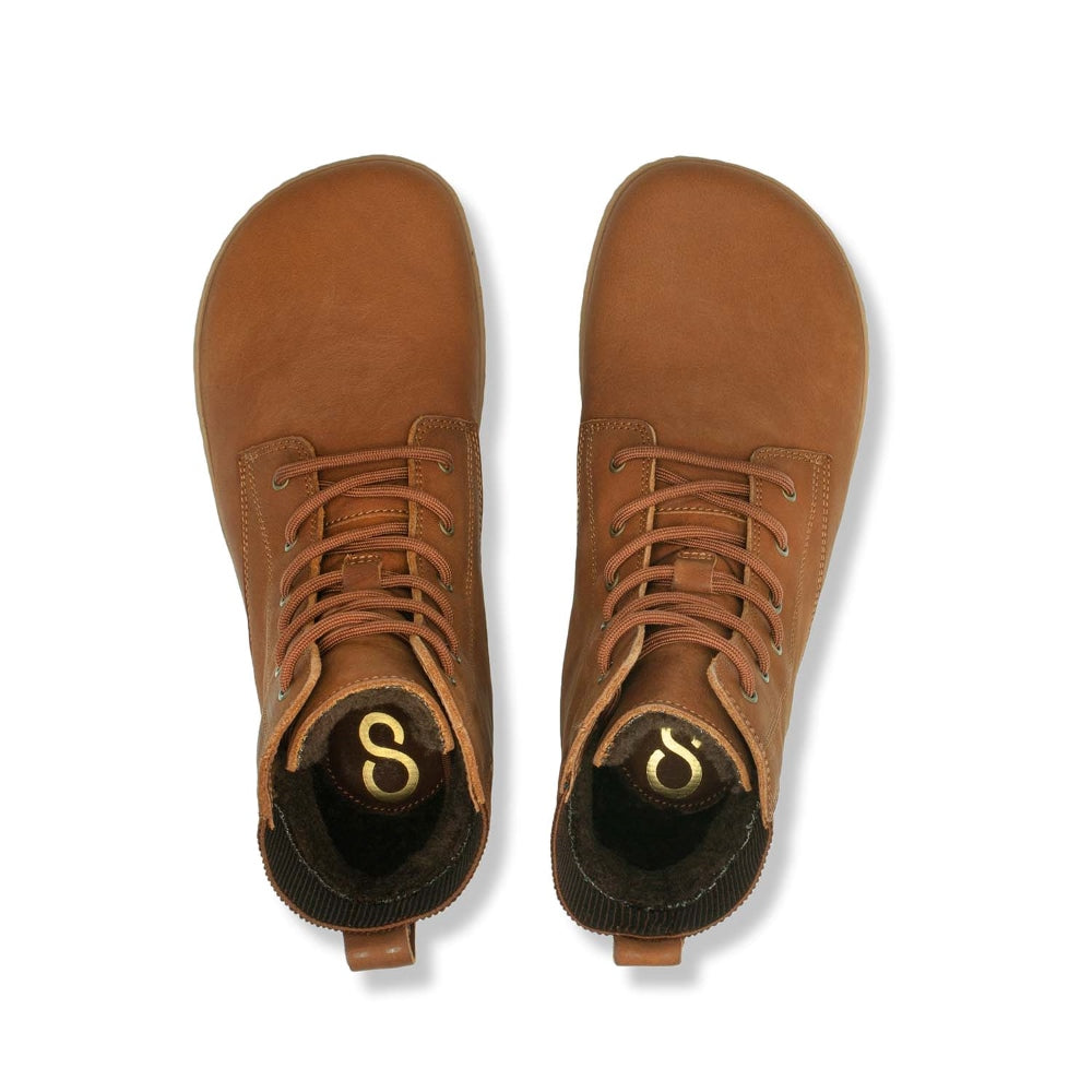 A photo of the Shapen Urbaneer combat boots made with nubuck leather, a thin wool lining, and rubber soles. The boots are caramel brown in color and have an elasticized panel on the top back of the boot. Both boots are shown together from above on a white background. #color_caramel