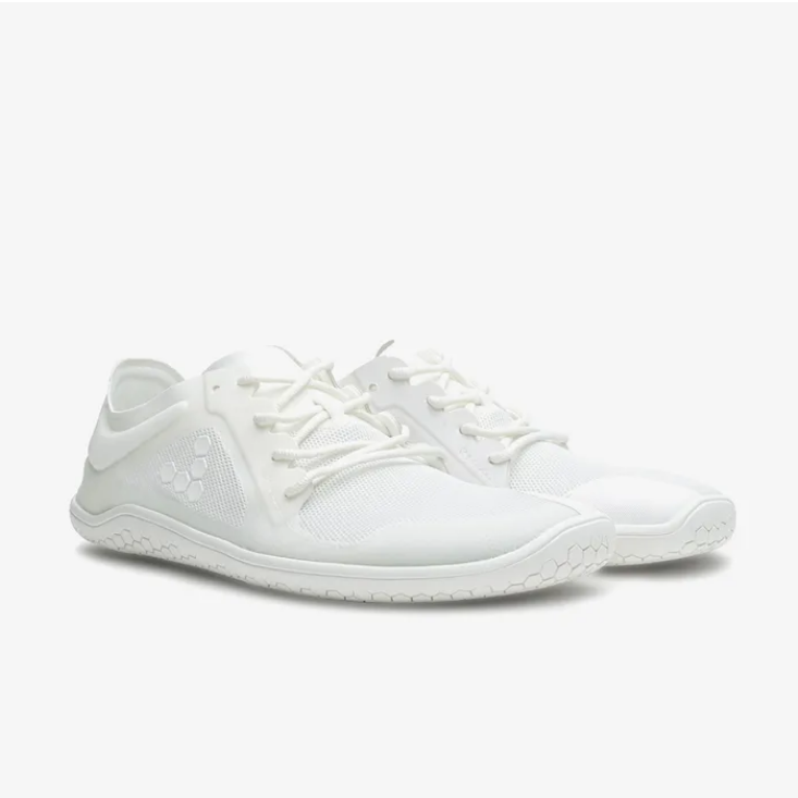 A photo of Vivobarefoot Primus lite sneakers made from recycled plastic and a rubber sole. The athletic sneakers are a white color with white soles and the vivobarefoot logo on the side. Both shoes are shown beside each other from the right side angled slightly from the front against a white background. #color_bright-white