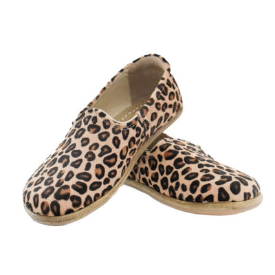 A photo of Yasemin Leather loafers Designed by Anya with a leather upper and tan rubber soles. The loafers are a leopard print color with a calf hair leather upper and have a small curve up on the top of the foot for design. Both loafers are shown facing opposite directions with the heel of the right shoe is leaning on the left shoe against a white background. #color_leopard-print-calf-hair