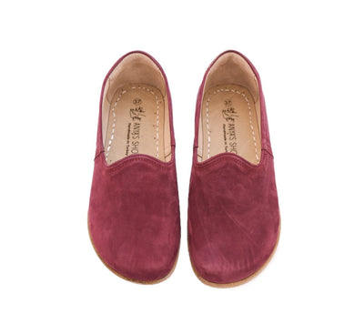 A photo of Yasemin Leather loafers Designed by Anya with a leather upper and tan rubber soles. The loafers are a mauve color with a nubuck leather upper and have a small curve up on the top of the foot for design. Both loafers are shown from the top facing down against a white background. #color_mauve-nubuck