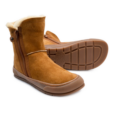 A photo of Zapatos Feroz Alcoy made with suede, sheepskin, and rubber soles. The boots are nut brown in color with rubber around the soles and a zipper on the side. Both boots are shown beside each other, the boots are facing right with the left boot lying on it’s side to show the sole. #color_nut-brown