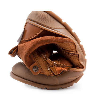 A photo of Zapatos Feroz Alcoy made with microfiber and rubber soles. The boots are nut brown in color with rubber around the soles and a zipper on the side. One boot is shown rolled into a ball to show flexibility against a white background. #color_nut-brown