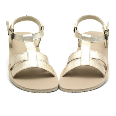 A photo of Zeezoo Freya Gold sandals made with leather and light beige leather topped rubber soles. The sandal straps are shiny they have double straps in the front, a single strap running up the middle of the foot,  around the ankle and heel with a small buckle. Both sandals are shown from the front beside each other against a white background in this photo. #color_gold