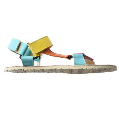 A photo of Zeezoo Olymp Rainbow sandals made from leather with velcro and a light beige leather topped rubber soles. The sandal straps are pink, light blue, orange, and yellow. The straps cross the front of the foot and a single strap runs along the outside of the top of the foot and around the ankle and heel. One sandal is shown from the right side against a white background in this photo.  #color_rainbow-olymp