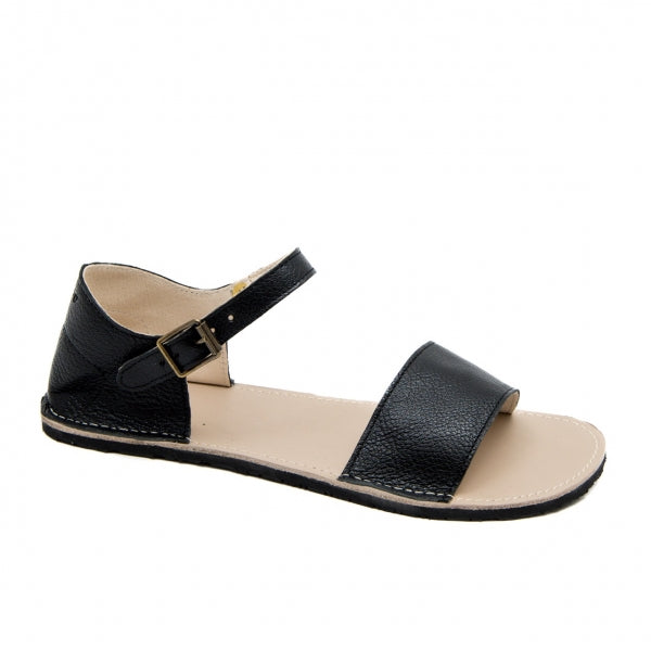 A photo of Zeezoo Siren Black Sandals made of leather and a light beige leather topped black rubber sole. The sandals have a front foot crossing strap, a leather ankle strap and heel cup. One sandal is shown from the right side against a white background in this photo. #color_black